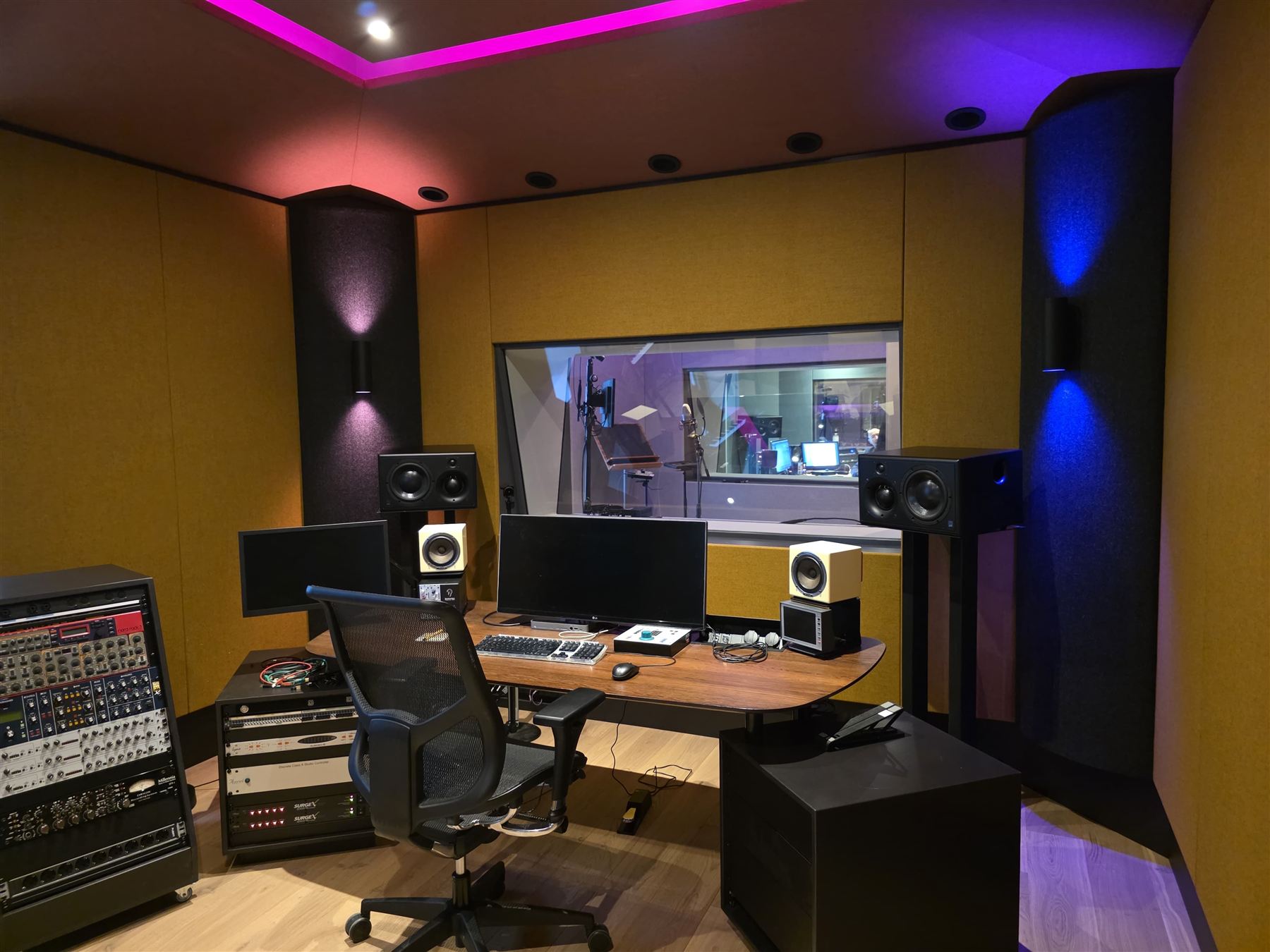 Compact mixing room with ochre wall fabric and purple-blue LED ambient lighting